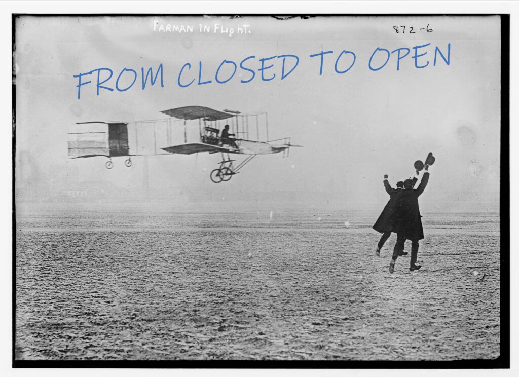 1909 Farman flying machine in flight, two men wave hats to greet pilot